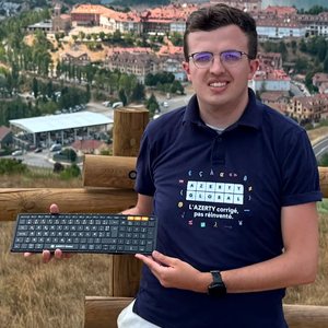 Antoine OLIVIER tenant un clavier portant le logo AZERTY Global